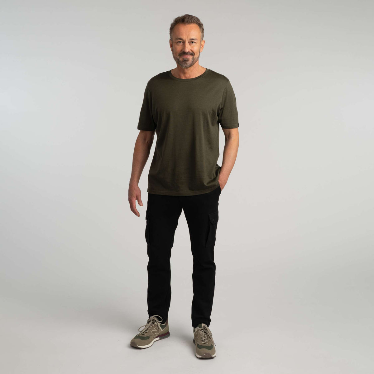 North Outdoor Liam miesten merino T-paita värissä tumma oliivi, mulesing-vapaa merinovilla. Suunniteltu Suomessa. - Malli on 181 cm ja käyttää kokoa L