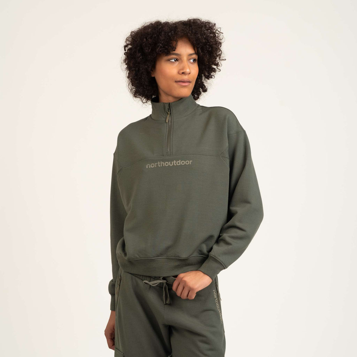 North Outdoor All day 250 naisten vetoketjullinen merinopusero Freja värissä nokkonen, mulesing-vapaa merinovilla. Suunniteltu Suomessa. - Malli on 180 cm ja käyttää kokoa S