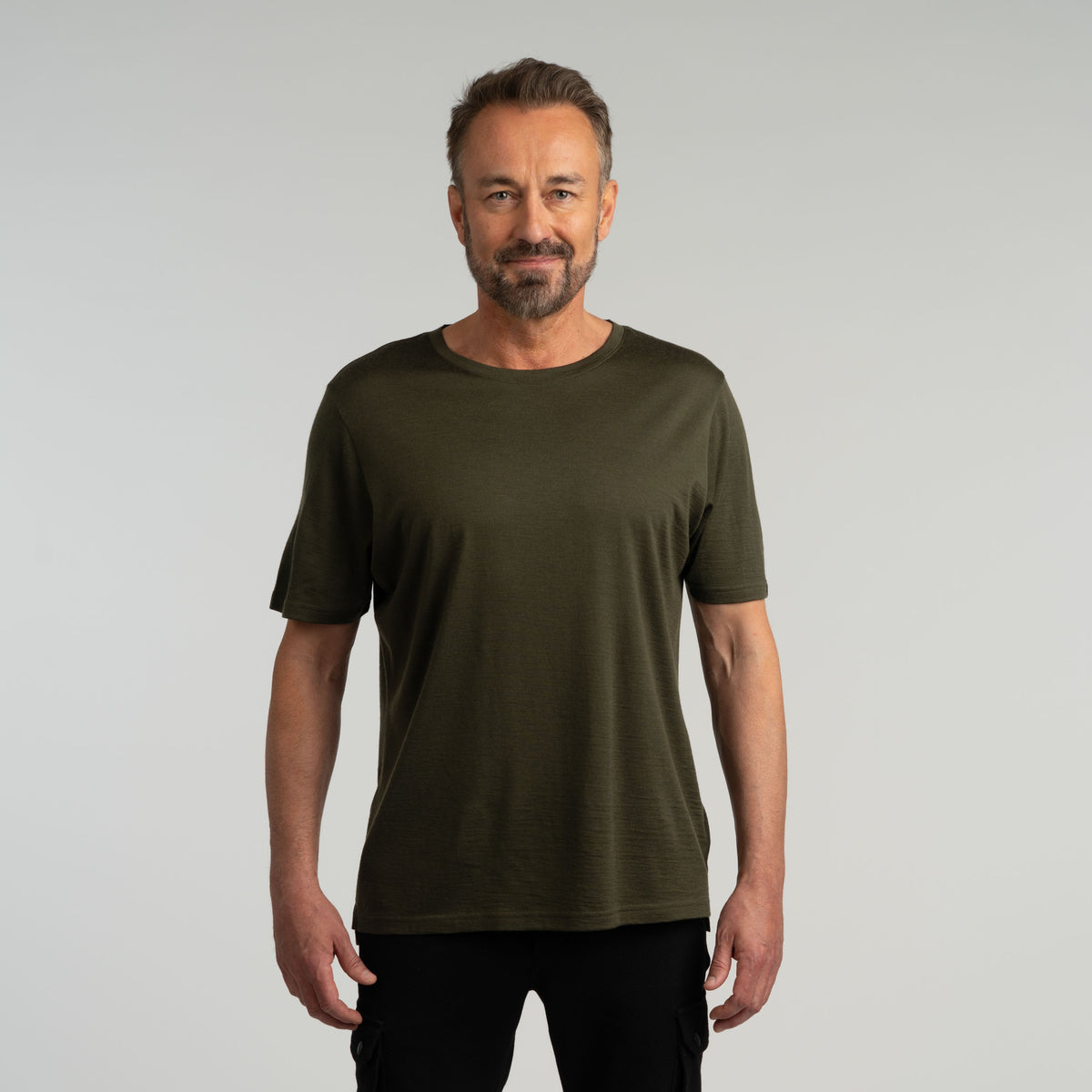 North Outdoor Liam miesten merino T-paita värissä tumma oliivi, mulesing-vapaa merinovilla. Suunniteltu Suomessa. - Malli on 181 cm ja käyttää kokoa L