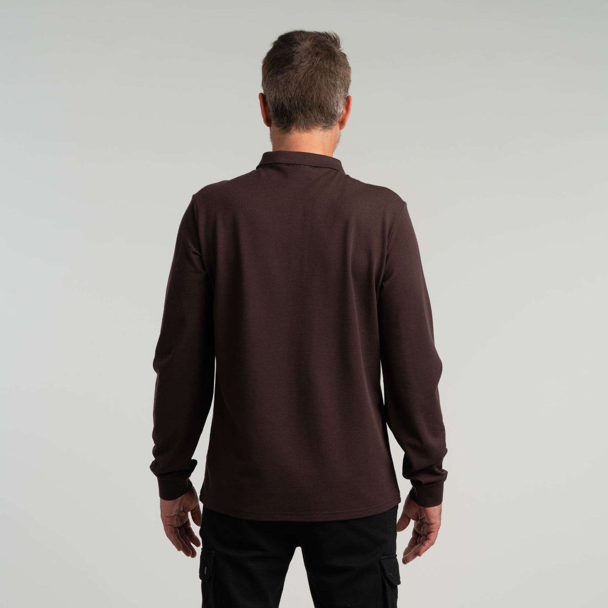 North Outdoor Jody miesten pitkähihainen merinopikeepaita värissä suklaa, mulesing-vapaa merinovilla. Suunniteltu Suomessa. - Malli on 181 cm ja käyttää kokoa L