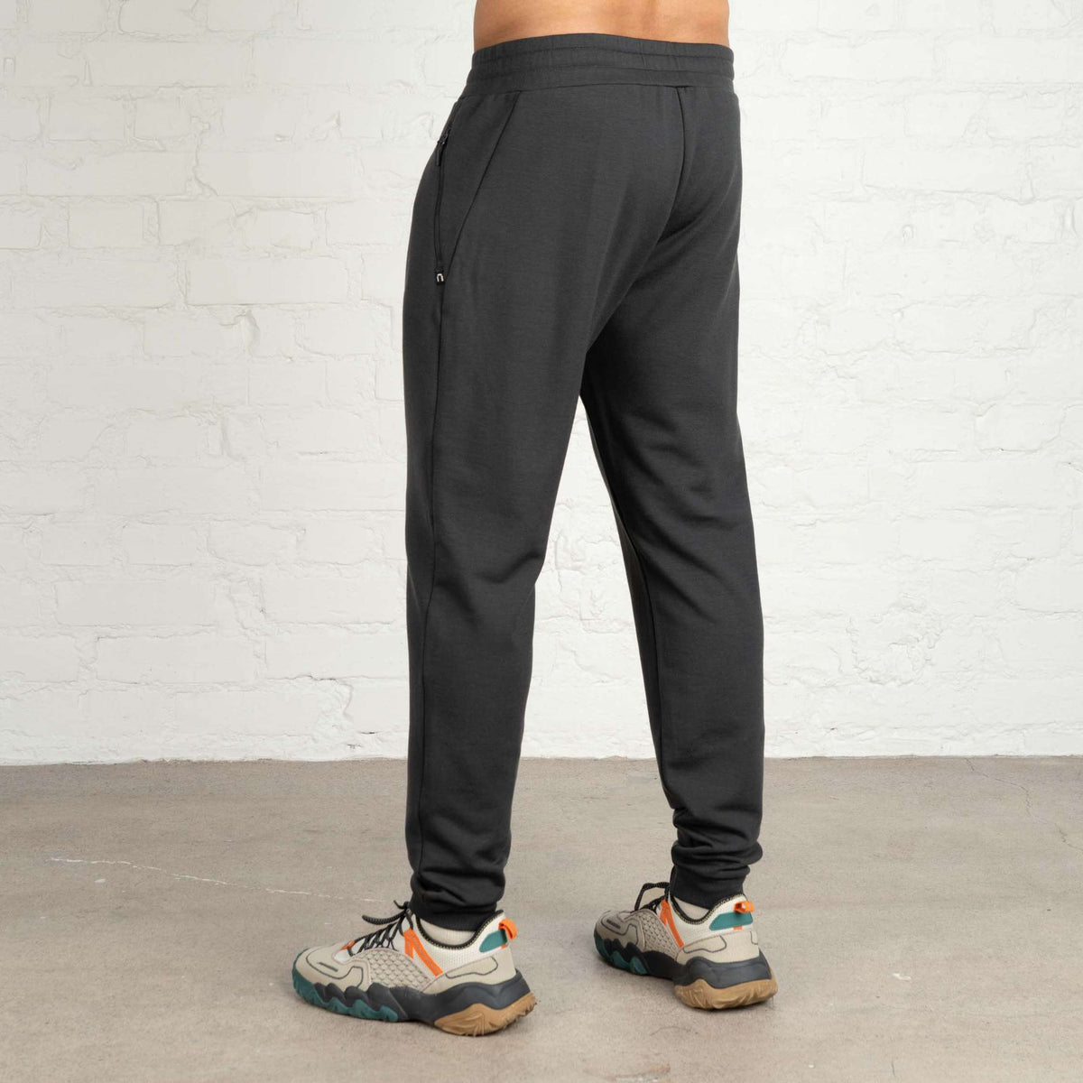 North Outdoor Finley Herren-Merino-Fleecehose in Granitgrau mulesingfreie Merinowolle. Entworfen in Finnland. - Model ist 187 cm groß und trägt Größe XL