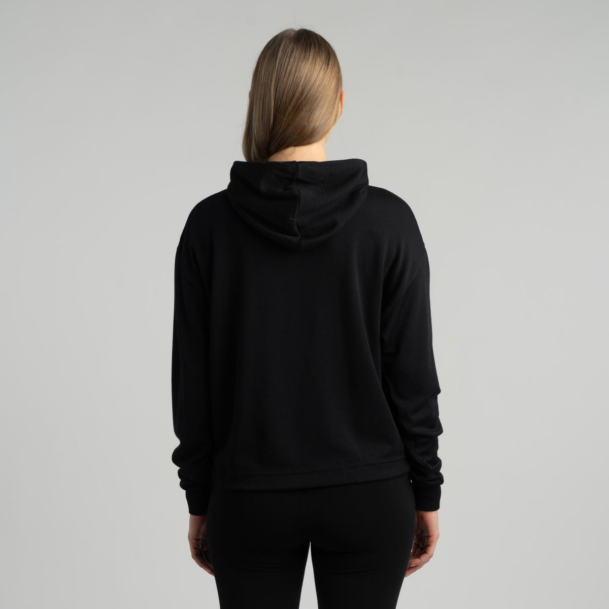 North Outdoor All day 260 Damen Cropped-Merino-Hoodie Edla in der Farbe Schwarz, Mulesing-frei Merinowolle. Entworfen in Finnland. - Das Model ist 174 cm groß und trägt Größe S