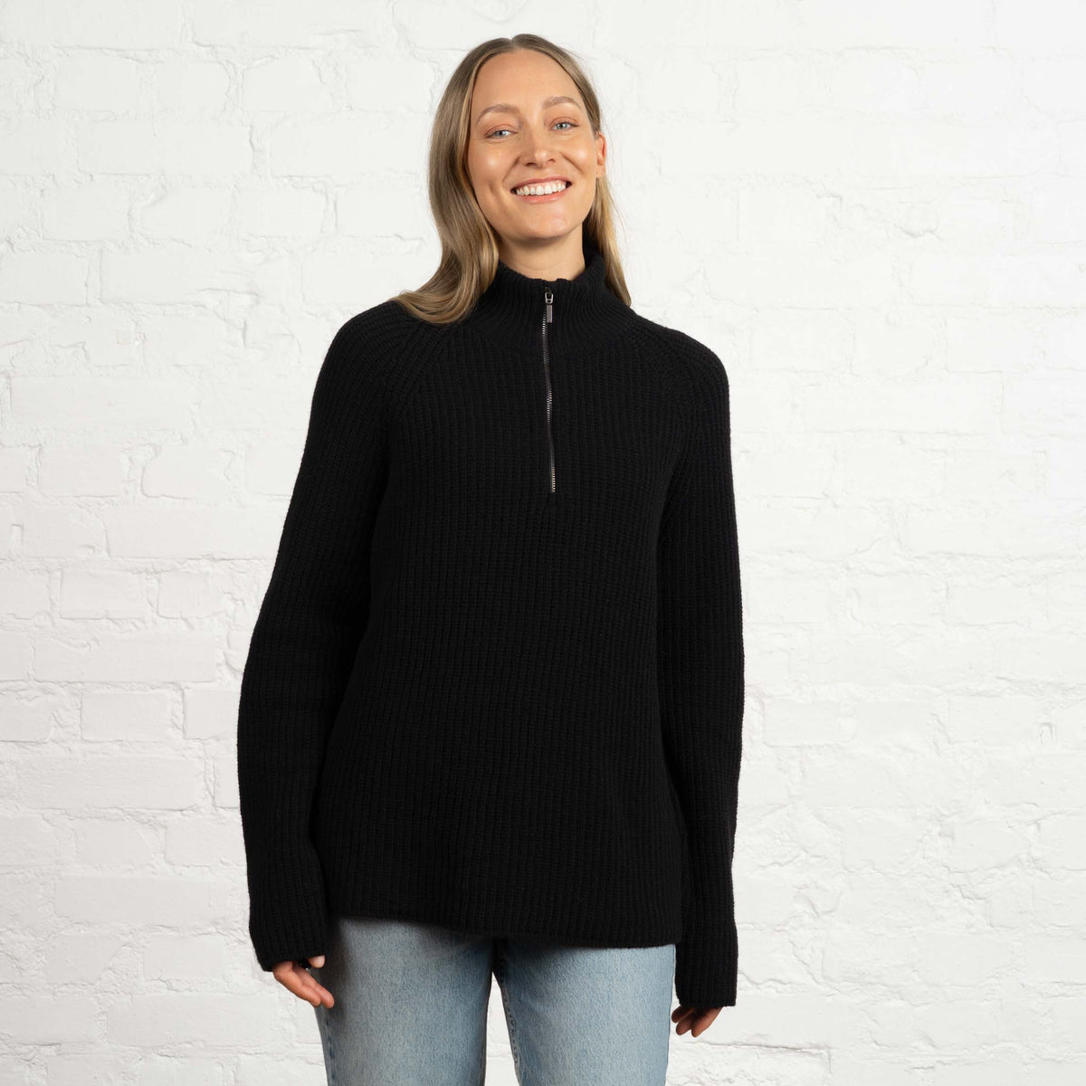 North Outdoor Magnolia Half Zip Merinoneule W värissä hiilenmusta, mulesing-vapaa merinovilla. Valmistettu Suomessa. - Malli on 174 cm ja käyttää kokoa M