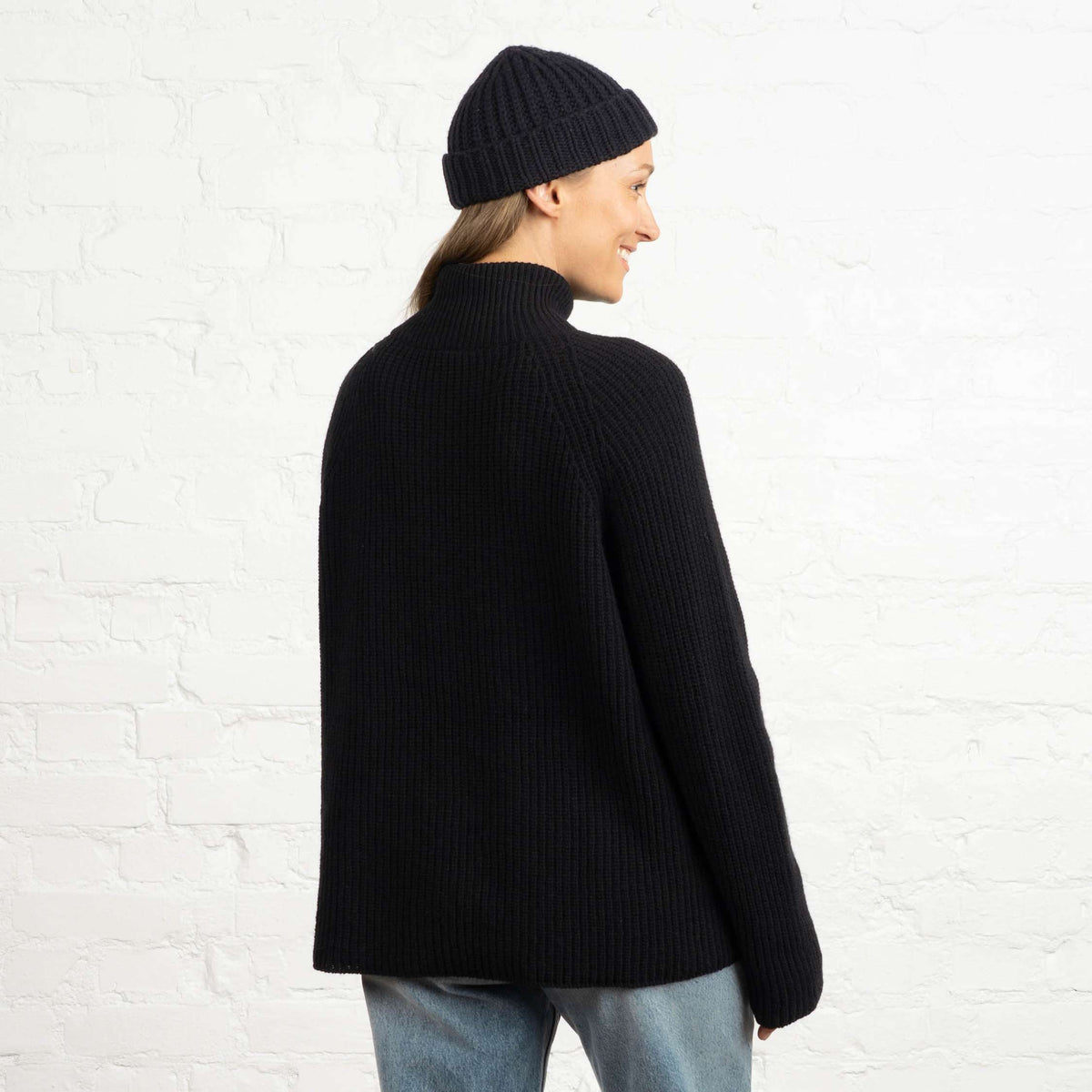 North Outdoor Magnolia Half Zip Merinoneule W värissä hiilenmusta, mulesing-vapaa merinovilla. Valmistettu Suomessa. - Malli on 174 cm ja käyttää kokoa M