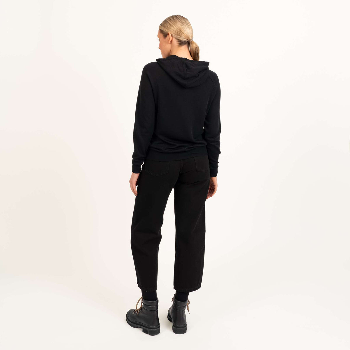 North Outdoor All Damen-Merino-Hoodie in Schwarz, mulesingfreie Merinowolle. Entworfen in Finnland - Model ist 176 cm groß und trägt Größe S